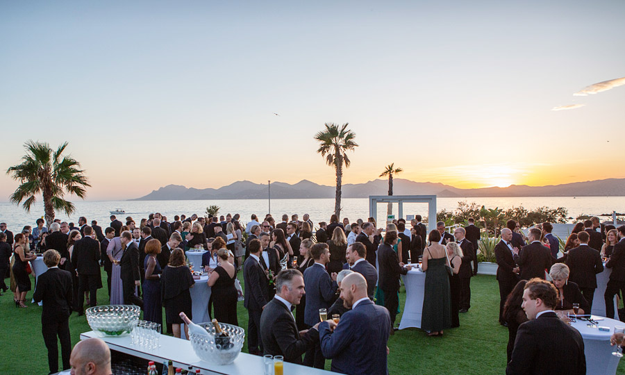 Title photo: guests celebrating a gala event at Cannes beach, sunny evening