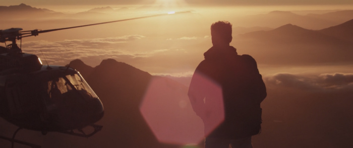 Sunset with helicopter, a person in the foreground, montains in the background